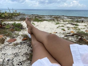 Low section of person relaxing on beach