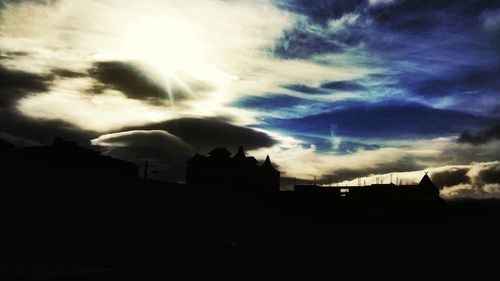 Silhouette of building against cloudy sky