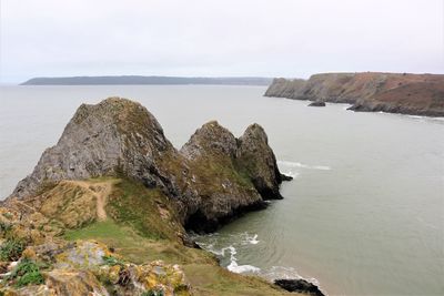 Scenic view of cliffs and sea against sky