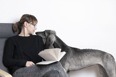 Young woman sitting on book