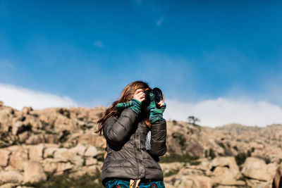 Woman photographing with umbrella standing on land