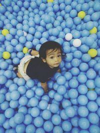 High angle portrait of baby playing with blue balls