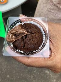 Close-up of hand holding chocolate cake