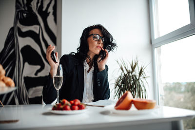 Businesswoman talking on phone while sitting in office