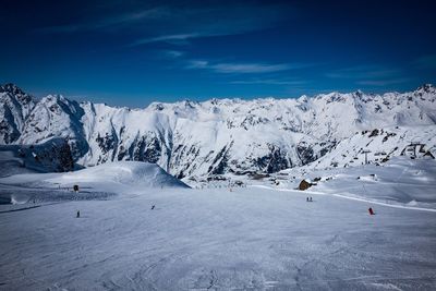 Scenic view of snowcapped mountains against blue sky