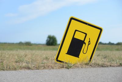 Close-up of yellow arrow sign on field