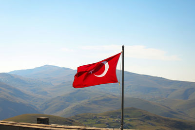Low angle view of flag against mountain range