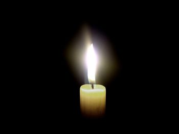 Close-up of lit candle in dark room