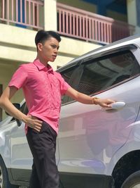 Side view of young woman holding car