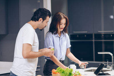 Young couple holding hands at home