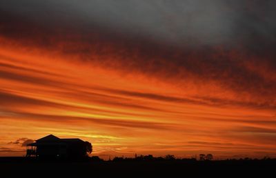 Scenic view of silhouette landscape against orange sky