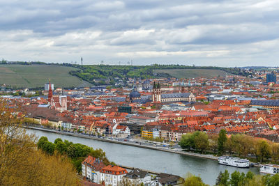 High angle view of townscape by river against sky