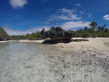 Scenic view of rocks on beach against sky