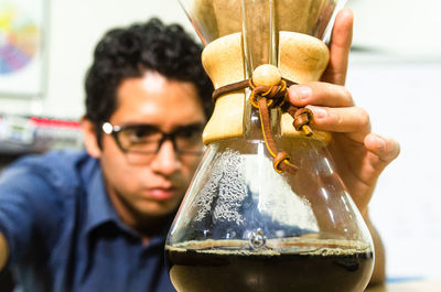 Close-up portrait of man holding glass