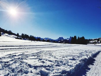 Scenic view of snow covered landscape against blue sky