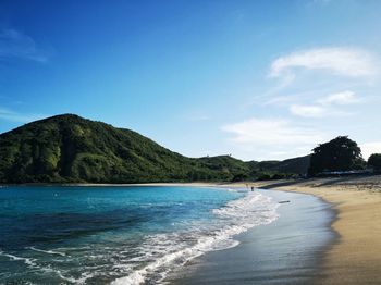 Scenic view of beach against blue sky