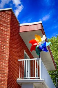 Low angle view of multi colored built structure against blue sky