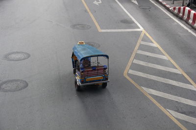 A tuk-tuk is driving on the road.