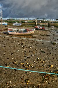 Boats moored on beach against sky