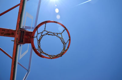 Basketball chain hoop with sunbeams and blue sky as background