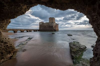 Torre astura by sea seen through arch of rock