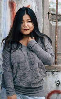 Portrait of beautiful woman standing against wall