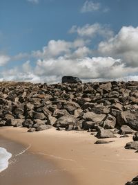 Scenic view of rocky beach against sky