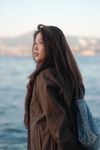 Portrait of young woman lying on bed at home