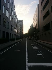 Empty road with buildings in background