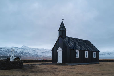 Church against cloudy sky during winter