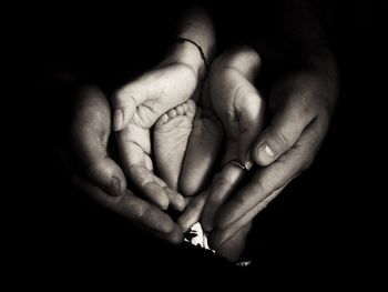 Cropped image of parents holding baby feet