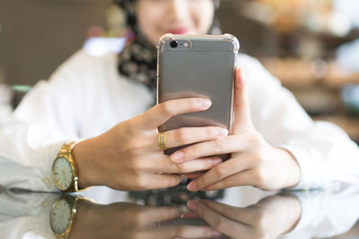 Midsection of woman using mobile phone