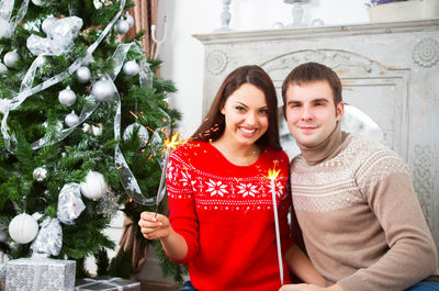 Portrait of a smiling young woman with christmas tree