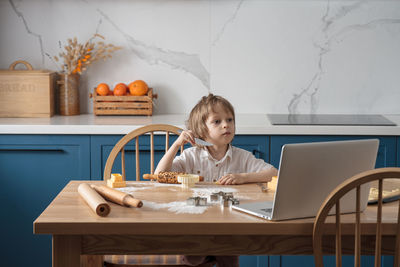 Boy sitting on table at home