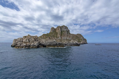 Rock formation in sea against sky