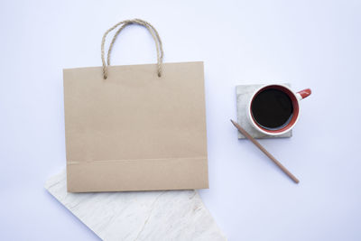 A paper bag with coffee and pencil was placed on a white background,top view, flat lay