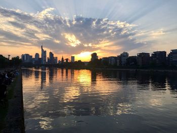 Reflection of buildings in lake during sunset