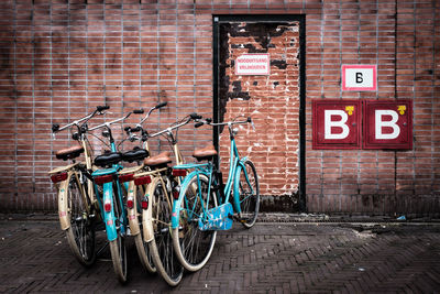 Bicycle parked against brick wall