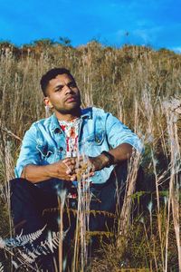 Portrait of young man looking away on field