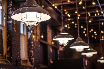 Low angle view of illuminated pendant light hanging from ceiling