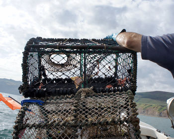 Person holding fishing basket in boat