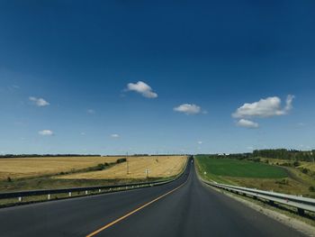 Empty road along countryside landscape