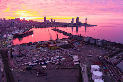 High angle view of river and buildings against sky at sunset