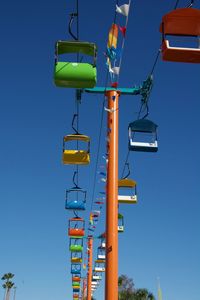 Low angle view of colorful ski lifts against clear blue sky