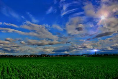 Scenic view of field against cloudy sky