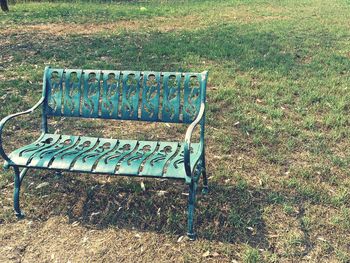 Empty bench on field in park