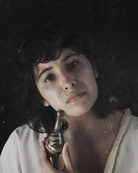 Close-up portrait of a young woman drinking glass