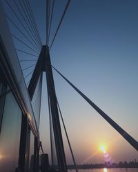 Low angle view of suspension bridge against sky during sunset