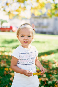 Portrait of cute girl standing on field