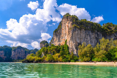 Panoramic view of rocks by sea against sky